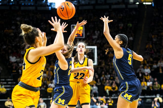 Iowa guard Caitlin Clark (22) passes the ball to Iowa guard Gabbie Marshall, left, during a NCAA Big Ten Conference women's basketball game against Michigan, Sunday, Feb. 27, 2022, at Carver-Hawkeye Arena in Iowa City, Iowa.