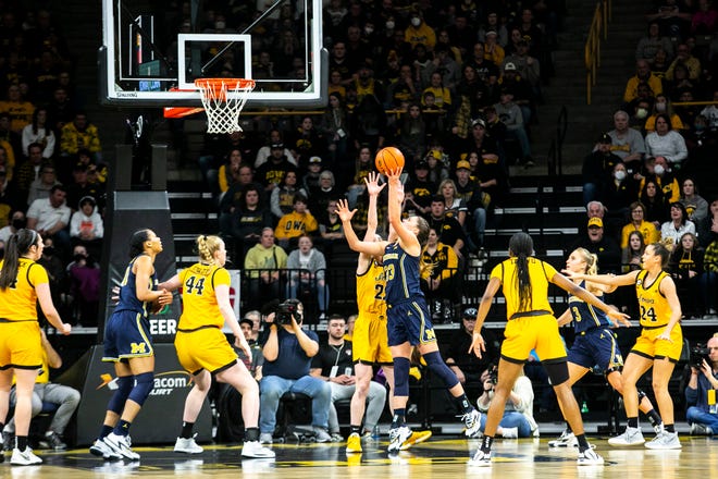 Michigan forward Emily Kiser (33) makes a basket as Iowa guard Caitlin Clark (22) defends during a NCAA Big Ten Conference women's basketball game, Sunday, Feb. 27, 2022, at Carver-Hawkeye Arena in Iowa City, Iowa.