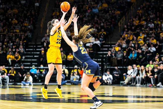 Iowa guard Caitlin Clark, left, makes a 3-point basket as Michigan guard Danielle Rauch defends during a NCAA Big Ten Conference women's basketball game, Sunday, Feb. 27, 2022, at Carver-Hawkeye Arena in Iowa City, Iowa.
