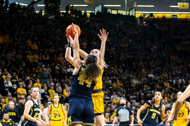 Iowa center Monika Czinano, right, makes a basket as Michigan forward Cameron Williams defends during a NCAA Big Ten Conference women's basketball game, Sunday, Feb. 27, 2022, at Carver-Hawkeye Arena in Iowa City, Iowa.