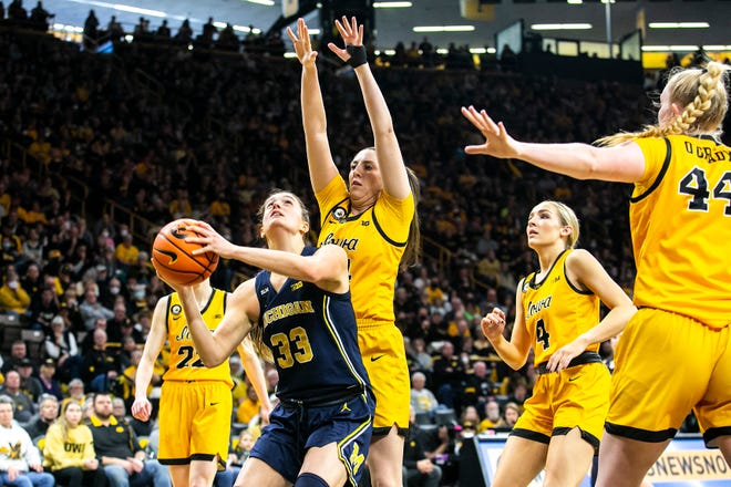 Michigan forward Emily Kiser (33) shoots a basket as Iowa guards Gabbie Marshall, behind, and Kylie Feuerbach (4) defend during a NCAA Big Ten Conference women's basketball game, Sunday, Feb. 27, 2022, at Carver-Hawkeye Arena in Iowa City, Iowa.
