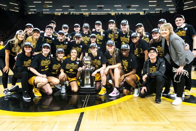 Iowa Hawkeyes players pose for a photo while celebrating with their Big Ten regular season championship trophy with head coach Lisa Bluder, right, after a NCAA Big Ten Conference women's basketball game against Michigan, Sunday, Feb. 27, 2022, at Carver-Hawkeye Arena in Iowa City, Iowa.