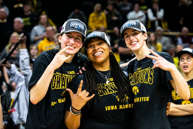 Iowa guards Kate Martin, left, and Caitlin Clark pose for a photo with Iowa assistant coach Raina Harmon after a NCAA Big Ten Conference women's basketball game against Michigan, Sunday, Feb. 27, 2022, at Carver-Hawkeye Arena in Iowa City, Iowa.