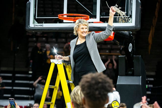 Iowa head coach Lisa Bluder waves the net while celebrating after a NCAA Big Ten Conference women's basketball game against Michigan, Sunday, Feb. 27, 2022, at Carver-Hawkeye Arena in Iowa City, Iowa.