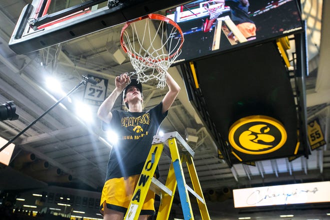Iowa guard Caitlin Clark (22) cuts down a piece of the net after a NCAA Big Ten Conference women's basketball game against Michigan, Sunday, Feb. 27, 2022, at Carver-Hawkeye Arena in Iowa City, Iowa.