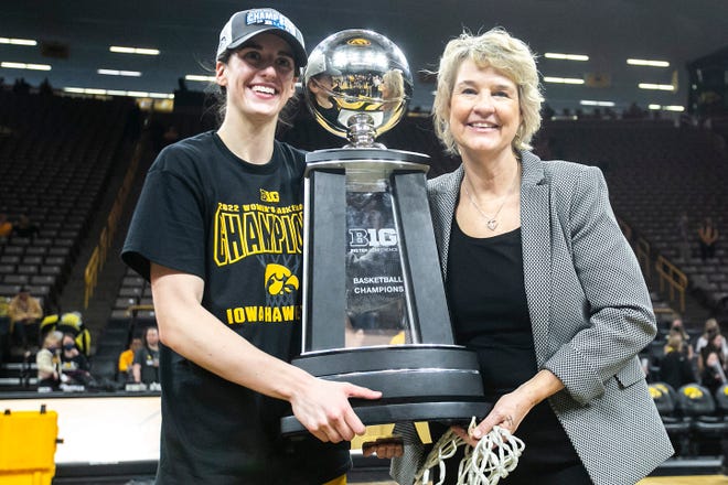 Iowa guard Caitlin Clark, left, poses for a photo with Iowa head coach Lisa Bluder as they hold their Big Ten regular season championship trophy after a NCAA Big Ten Conference women's basketball game against Michigan, Sunday, Feb. 27, 2022, at Carver-Hawkeye Arena in Iowa City, Iowa.