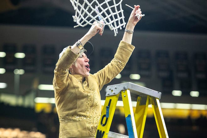 Iowa associate head coach Jan Jensen celebrates with a piece of the net after a NCAA Big Ten Conference women's basketball game against Michigan, Sunday, Feb. 27, 2022, at Carver-Hawkeye Arena in Iowa City, Iowa.