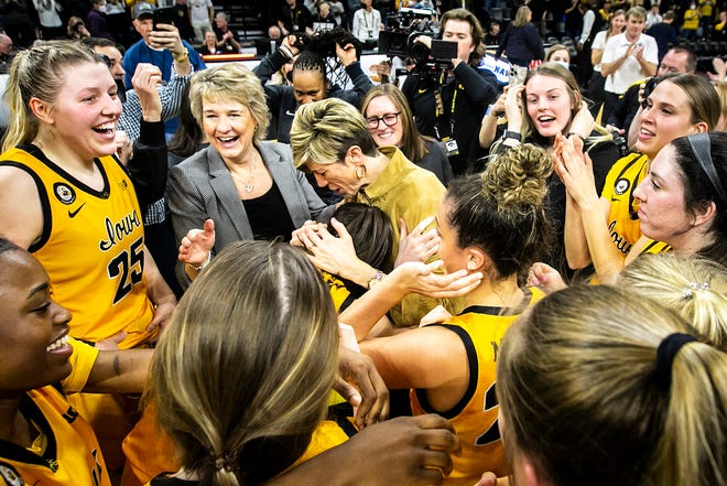 Iowa head coach Lisa Bluder and associate head coach Jan Jensen along with center Monika Czinano and guard Caitlin Clark (22) celebrate with teammates after a NCAA Big Ten Conference women's basketball game against Michigan, Sunday, Feb. 27, 2022, at Carver-Hawkeye Arena in Iowa City, Iowa.