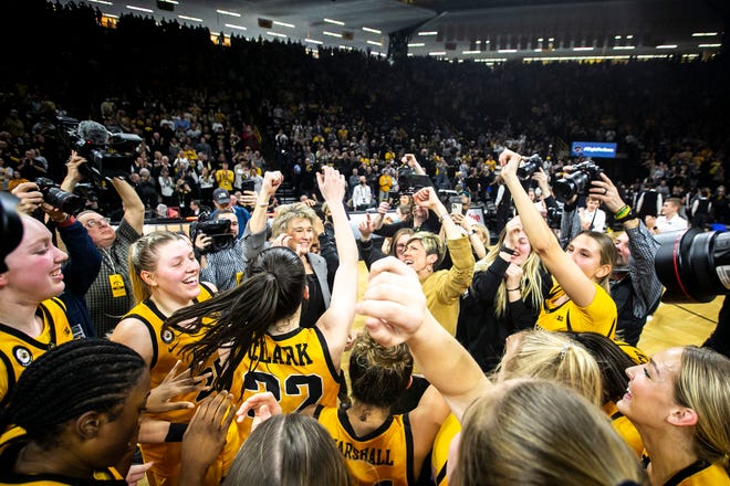 Iowa head coach Lisa Bluder and associate head coach Jan Jensen along with center Monika Czinano and guard Caitlin Clark (22) celebrate with teammates after a NCAA Big Ten Conference women's basketball game against Michigan, Sunday, Feb. 27, 2022, at Carver-Hawkeye Arena in Iowa City, Iowa.