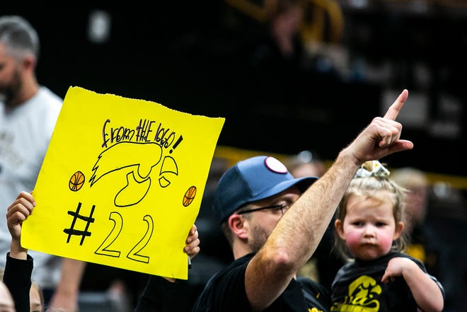 A fan holds a sign reading "From the logo!" for Iowa guard Caitlin Clark after a NCAA Big Ten Conference women's basketball game against Michigan, Sunday, Feb. 27, 2022, at Carver-Hawkeye Arena in Iowa City, Iowa.