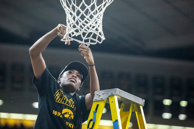 Iowa guard Tomi Taiwo cuts down a piece of the net after a NCAA Big Ten Conference women's basketball game against Michigan, Sunday, Feb. 27, 2022, at Carver-Hawkeye Arena in Iowa City, Iowa.
