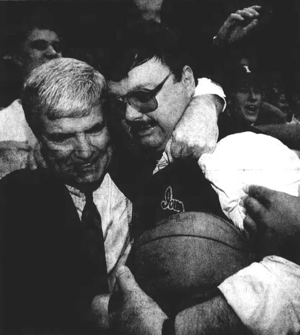 Tom Davis, left, embraces Mike Street, father of Chris Street, who was given the game ball after Iowa's win over Michigan in 1993.