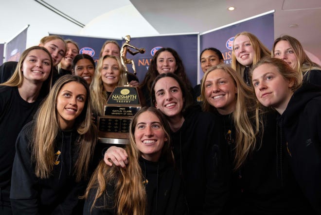 Caitlin Clark poses for photos with her team after winning the 2023 Jersey Mike's Naismith Trophy in Dallas, Texas, Wednesday, March 29, 2023.